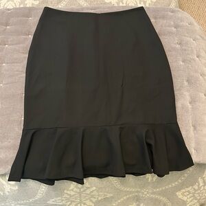 The Limted black knee length skirt with ruffled bottom hem. Side zip closure